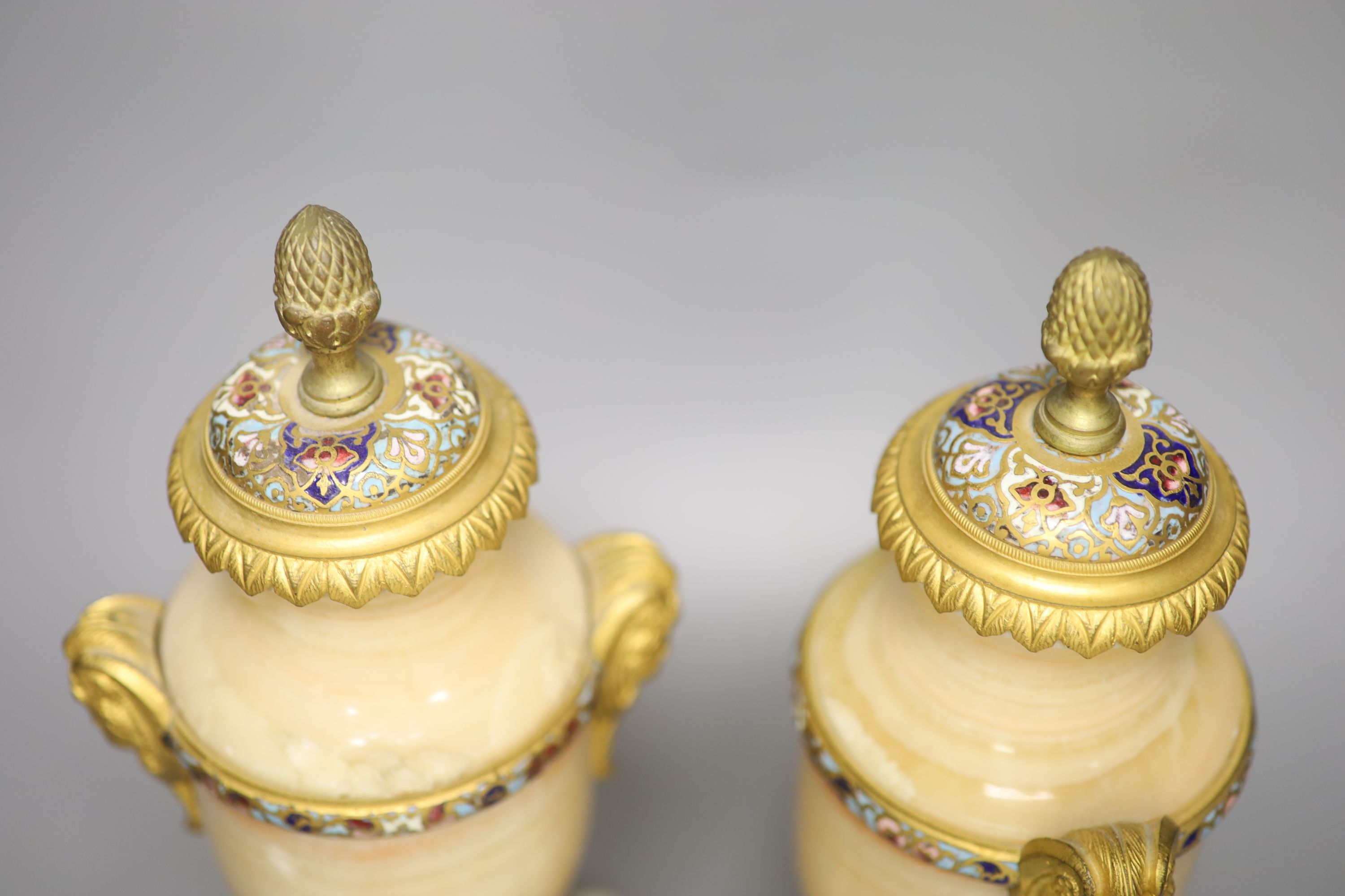 A pair of late 19th century alabaster and champleve enamel urns (formerly part of a clock garniture), height 32cm
